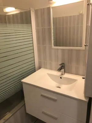 a bathroom with a white sink and a mirror at Joli T2 les pieds dans l’eau , piscine tennis.... in San-Nicolao