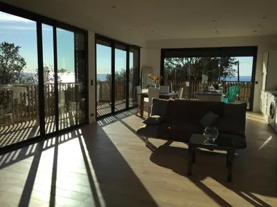 a living room with a couch and a table at Villa l'Alpana en bois vue mer a 180 degres in Sari Solenzara