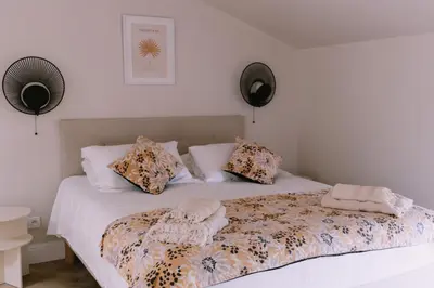 a bedroom with a bed with a comforter and pillows at L'Orangeraie d'Afa in Afa