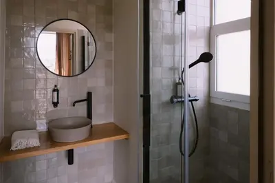 a bathroom with a shower with a mirror and a sink at L'Orangeraie d'Afa in Afa