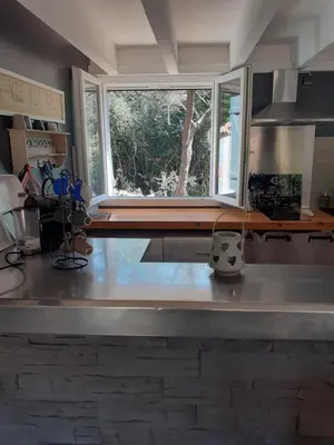 a kitchen with a stone island in the middle at Maison avec piscine chauffée in Porto-Vecchio