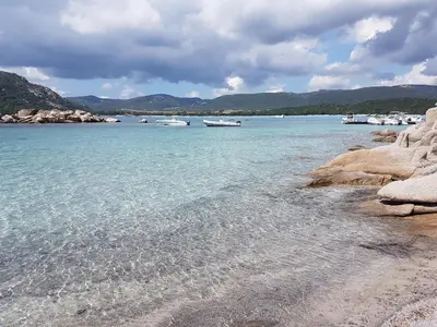 a wooden pier sticking out into the water on a beach at Maison avec piscine chauffée in Porto-Vecchio