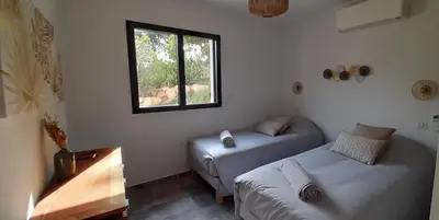 a bedroom with two beds and a window at Un petit paradis in Pinarellu