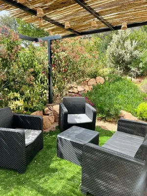 a patio with chairs and tables on the grass at Un petit paradis in Pinarellu
