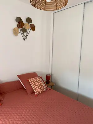a bedroom with a bed with a red bedspread at Petite maison en pierre in Afa