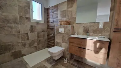 a bathroom with a toilet and a tub and a sink at Petite maison en pierre in Afa
