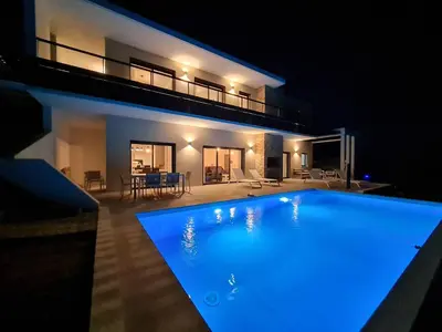 a swimming pool in front of a house at night at Villa Marcaléone Corse du Sud in Cirendinu