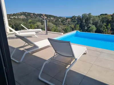 a patio with two chairs and a swimming pool at Villa Marcaléone Corse du Sud in Cirendinu