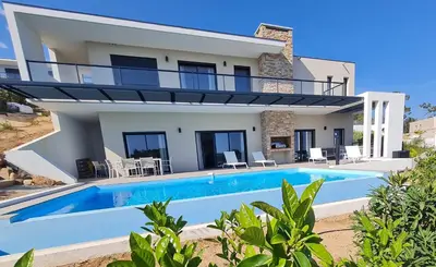a villa with a swimming pool in front of a house at Villa Marcaléone Corse du Sud in Cirendinu