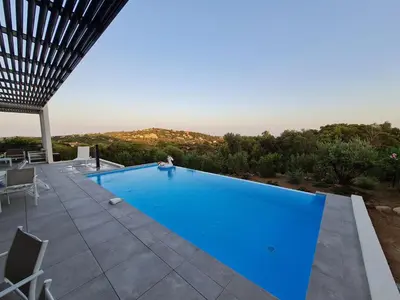 a large blue swimming pool on a patio at Villa Marcaléone Corse du Sud in Cirendinu