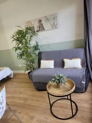 a living room with a blue couch and a table at Studio bord de mer - Plage - Piscine - Wifi in Santa-Lucia-di-Moriani