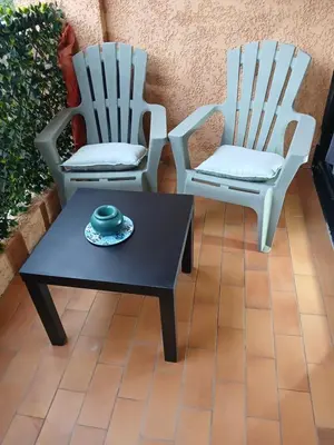 two chairs and a coffee table on a patio at Studio bord de mer - Plage - Piscine - Wifi in Santa-Lucia-di-Moriani