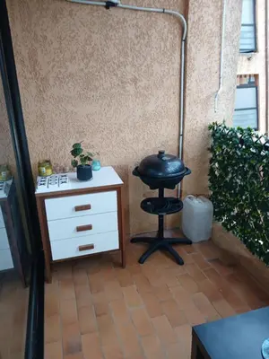 a patio with a table and a stool and a stove at Studio bord de mer - Plage - Piscine - Wifi in Santa-Lucia-di-Moriani