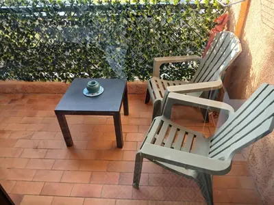 two chairs and a coffee table on a patio at Studio bord de mer - Plage - Piscine - Wifi in Santa-Lucia-di-Moriani
