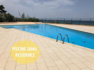 a swimming pool with a sign that reads pressureds resistance at Studio bord de mer - Plage - Piscine - Wifi in Santa-Lucia-di-Moriani