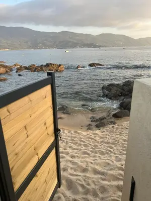 a door to the beach with the ocean in the background at PIEDS DANS L'EAU, TIUCCIA, appartement 2-4 pers in Casaglione