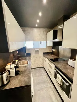 a large kitchen with white cabinets and blue appliances at PIEDS DANS L'EAU, TIUCCIA, appartement 2-4 pers in Casaglione
