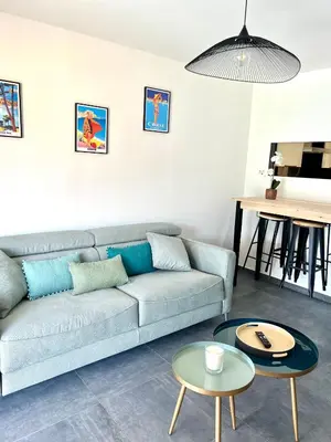 a living room with a couch and a table at PIEDS DANS L'EAU, TIUCCIA, appartement 2-4 pers in Casaglione