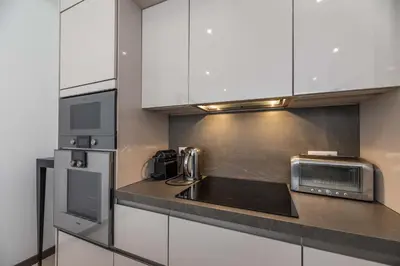 a kitchen with white cabinets and a sink and a microwave at Mogador in Bonifacio