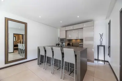 a kitchen with a bar with stools and a mirror at Mogador in Bonifacio