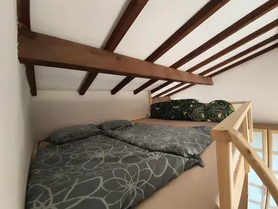 a bedroom with a bed and a loft at Apartment Liscia sea view, restaurant and supermarket 50m in Calcatoggio