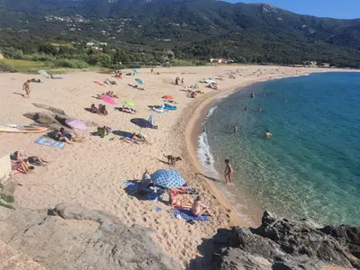 a group of people laying on a beach at Apartment Liscia sea view, restaurant and supermarket 50m in Calcatoggio