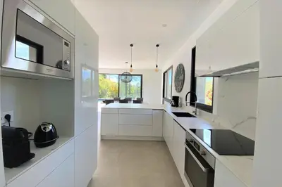 a white kitchen with white cabinets and a sink at Villa Ribba Di San Gavino in Gialla