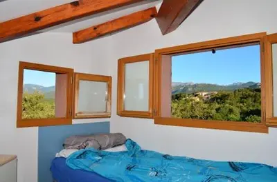 a bedroom with three windows and a bed in it at VARDIOLA/PORTO VECCHIO in Pinarellu