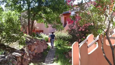 a woman walking down a path in front of a house at VARDIOLA/PORTO VECCHIO in Pinarellu
