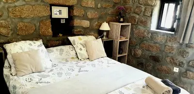a bedroom with a bed and a stone wall at Chez Robert et Sylvie in Pianottoli-Caldarello