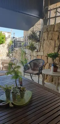 a patio with a table and a bench and potted plants at Chez Robert et Sylvie in Pianottoli-Caldarello