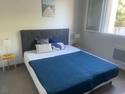 a bedroom with a large bed with a blue blanket at Maison pinarello à 200 mètres de la plage in Zonza