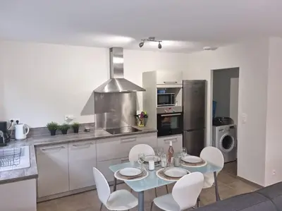 a kitchen with a table and chairs in a kitchen at Maison pinarello à 200 mètres de la plage in Zonza