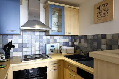 a kitchen with blue and white tiles on the wall at Les Sanguinaires N'16 - T2 Vue Mer, Piscine, Plage in Ajaccio