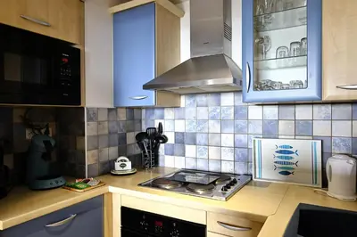 a kitchen with blue and white tiles on the wall at Les Sanguinaires N'16 - T2 Vue Mer, Piscine, Plage in Ajaccio