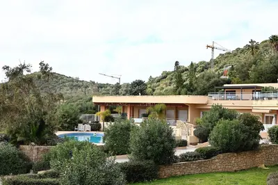 a house with a mountain in the background at Les Sanguinaires N'16 - T2 Vue Mer, Piscine, Plage in Ajaccio