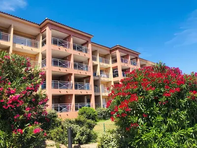 an apartment building with red flowers in front of it at Les Sanguinaires N'16 - T2 Vue Mer, Piscine, Plage in Ajaccio