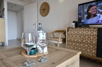 two wine glasses sitting on a table in a living room at Les Sanguinaires N'16 - T2 Vue Mer, Piscine, Plage in Ajaccio