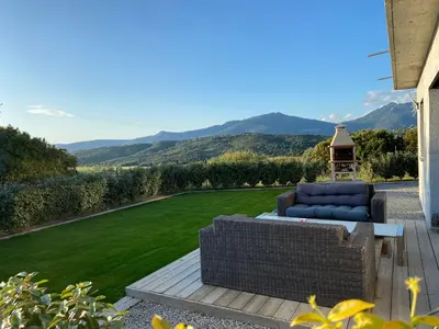 a patio with a couch and a lawn at Brindingaccia in Propriano