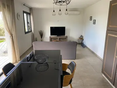 a living room with a table and a tv at Brindingaccia in Propriano