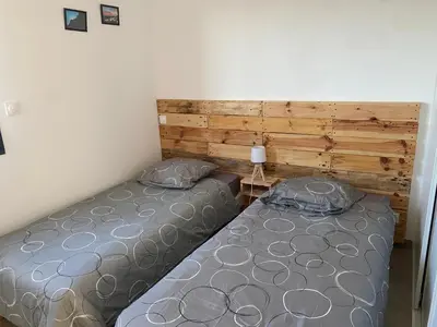 two twin beds in a bedroom with a wooden wall at Brindingaccia in Propriano