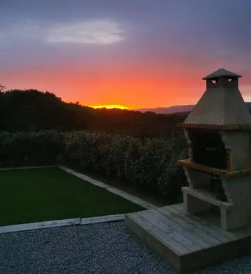 a sunset over a garden with a gazebo at Brindingaccia in Propriano