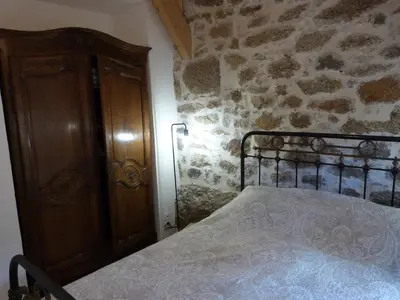 a bedroom with a bed and a wooden cabinet at U Caseddu Di Minnana in Petreto-Bicchisano