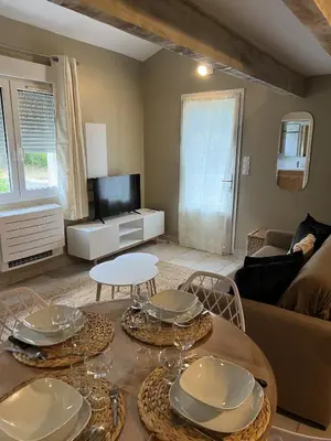 a living room with a table and chairs and a couch at Appartements St. Pancrace in Corte
