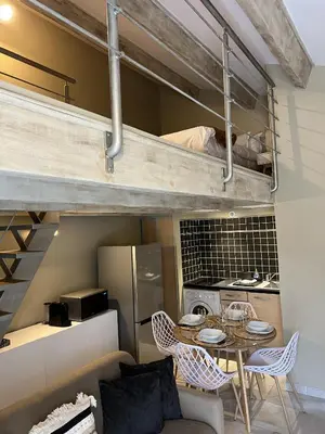 a room with a table and chairs and a kitchen at Appartements St. Pancrace in Corte
