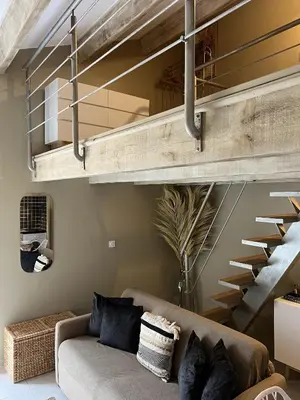 a living room with a couch and a staircase at Appartements St. Pancrace in Corte