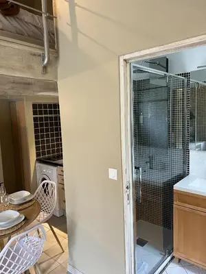 a kitchen with a glass door and a table and chairs at Appartements St. Pancrace in Corte