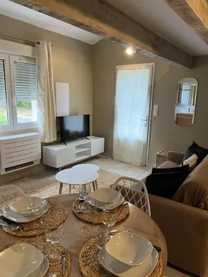 a living room with a table and a tv at Appartements St. Pancrace in Corte