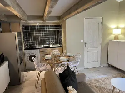 a living room with a table and chairs and a kitchen at Appartements St. Pancrace in Corte