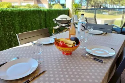 a table with plates and a bowl of fruit on it at Stella - Agosta beach by foot Terrace - by TGB in Porticcio
